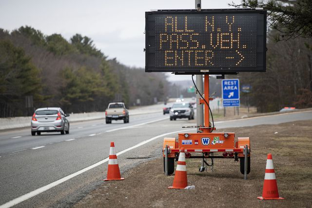 Sign instructs motorists with New York license plates to pull over at a checkpoint on I-95 over the border from Connecticut where New Yorkers must pull over and provide contact information and are told to self-quarantine for two weeks, in Hope Valley, R.I.